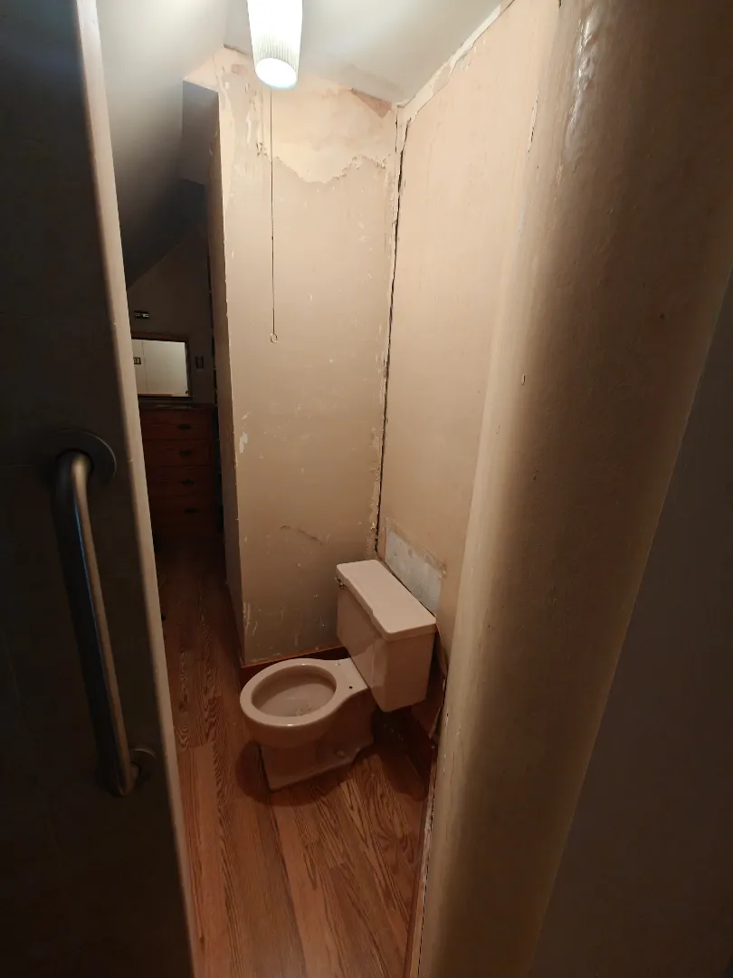 Small bathroom before wall repair and fixture updates
