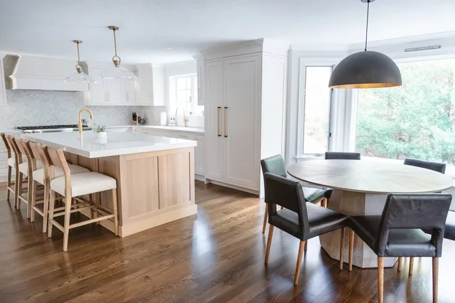 Rosewood Court kitchen and dining area with white cabinetry, white oak island, and round wood dining table