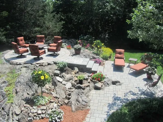 Completed stone patio with seating area and boulder accents