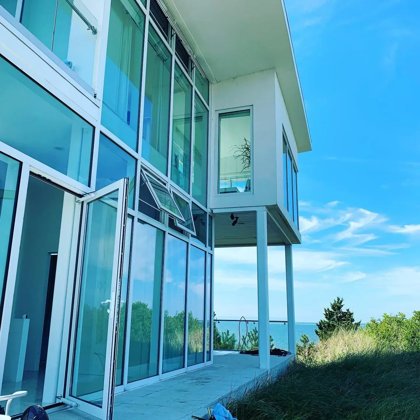 Modern Cape Cod beach house with large glass windows and ocean view cleaned