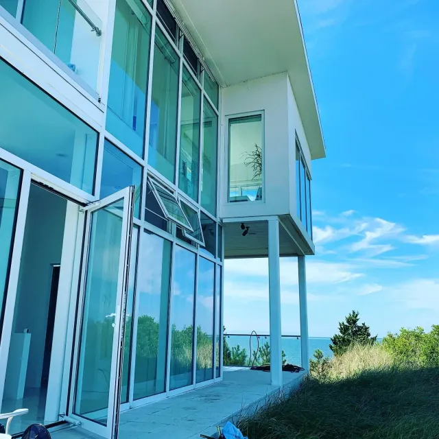 Modern Cape Cod beach house with large glass windows and ocean view cleaned