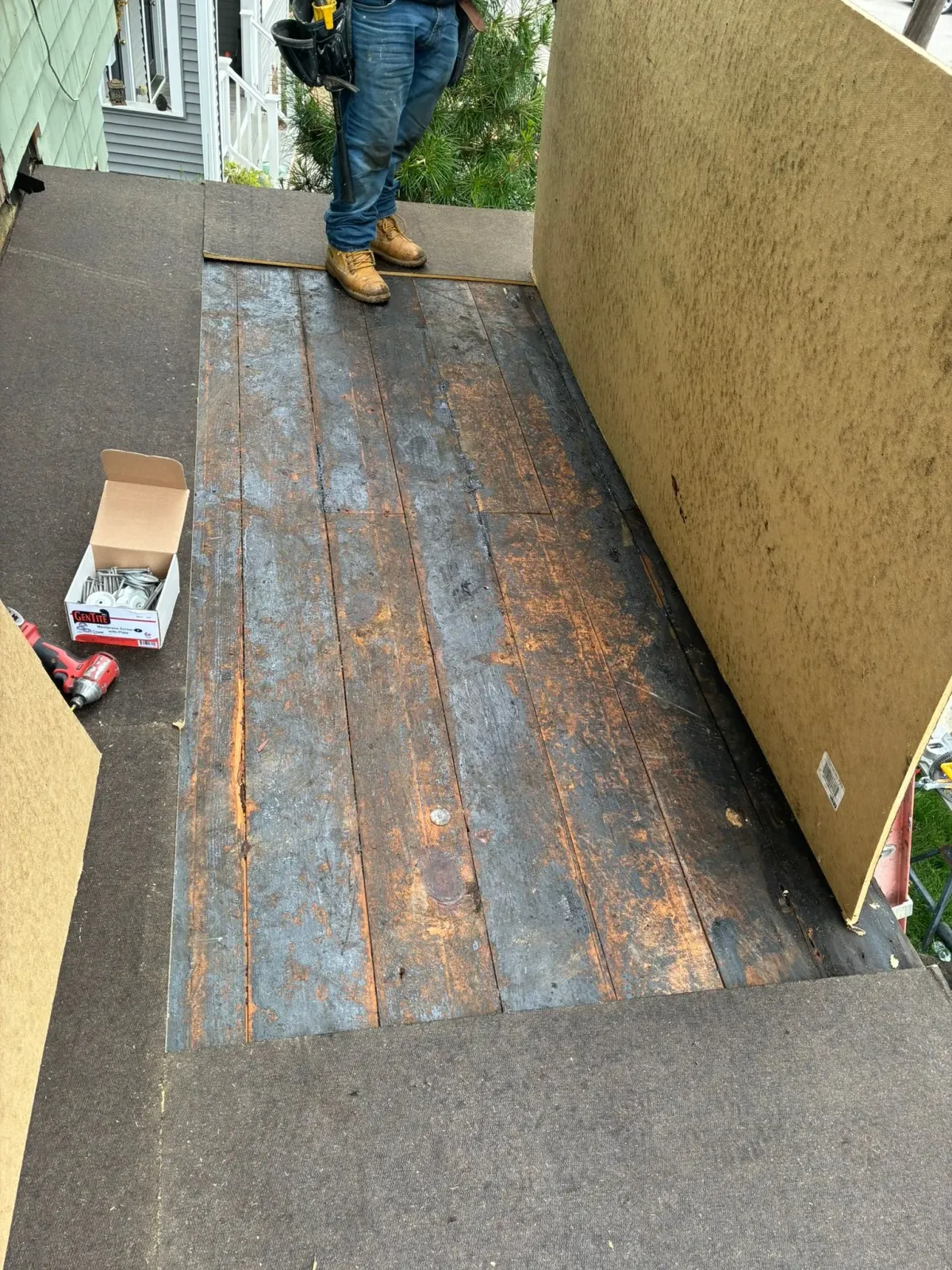 Person standing on a worn, rust-stained metal ramp between beige walls outdoors