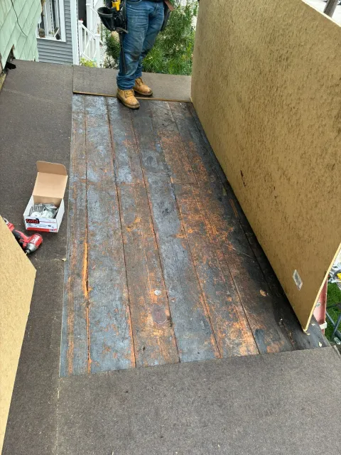 Person standing on a worn, rust-stained metal ramp between beige walls outdoors