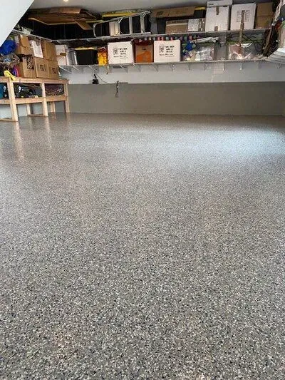 A garage floor with a lot of shelves and boxes on it.