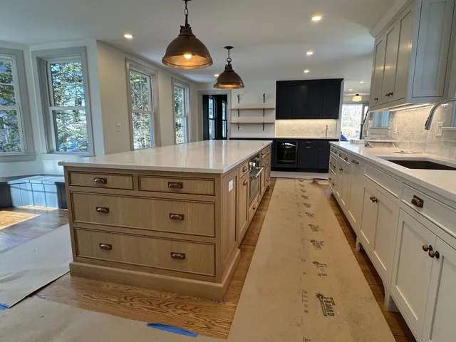 Long custom kitchen island in white oak with quartz countertop