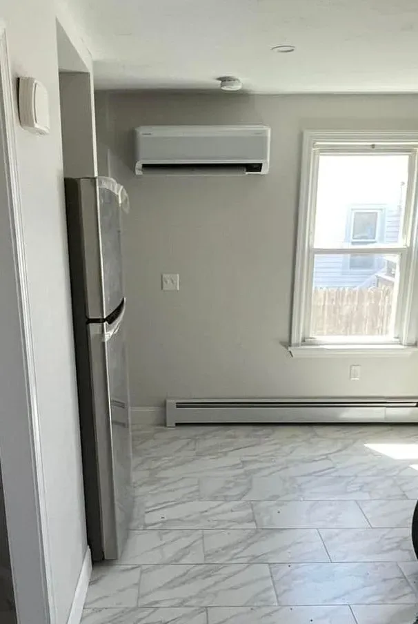 There is a refrigerator and a window in the room.
