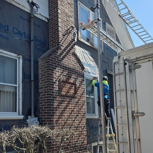 Siding and housewrap installation on a brick multi-family, crew on ladder