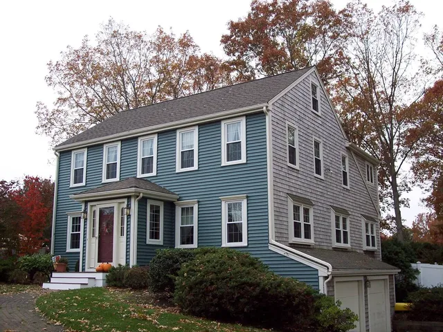 Historic home in Hingham featuring blue siding, double-hung windows, and a welcoming front entry with a porch, showcasing North Star-Bailey's exterior restoration services.