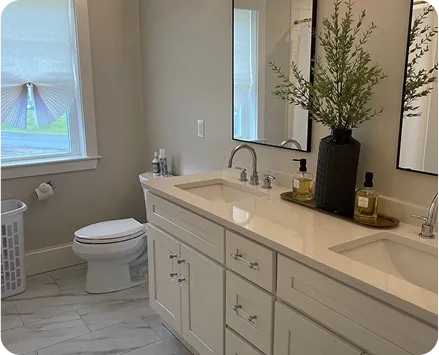 Spotless modern bathroom with a white double vanity and bright lighting after professional residential deep cleaning services.