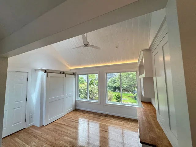 An empty room with hardwood floors and a ceiling fan