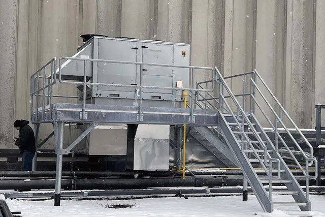 outdoor metal stairs and landing with large HVAC unit