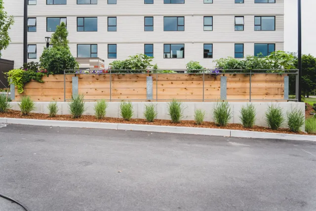 Expertly designed and maintained commercial landscape featuring raised garden beds and structured plantings, enhancing the aesthetic of a Vermont property.