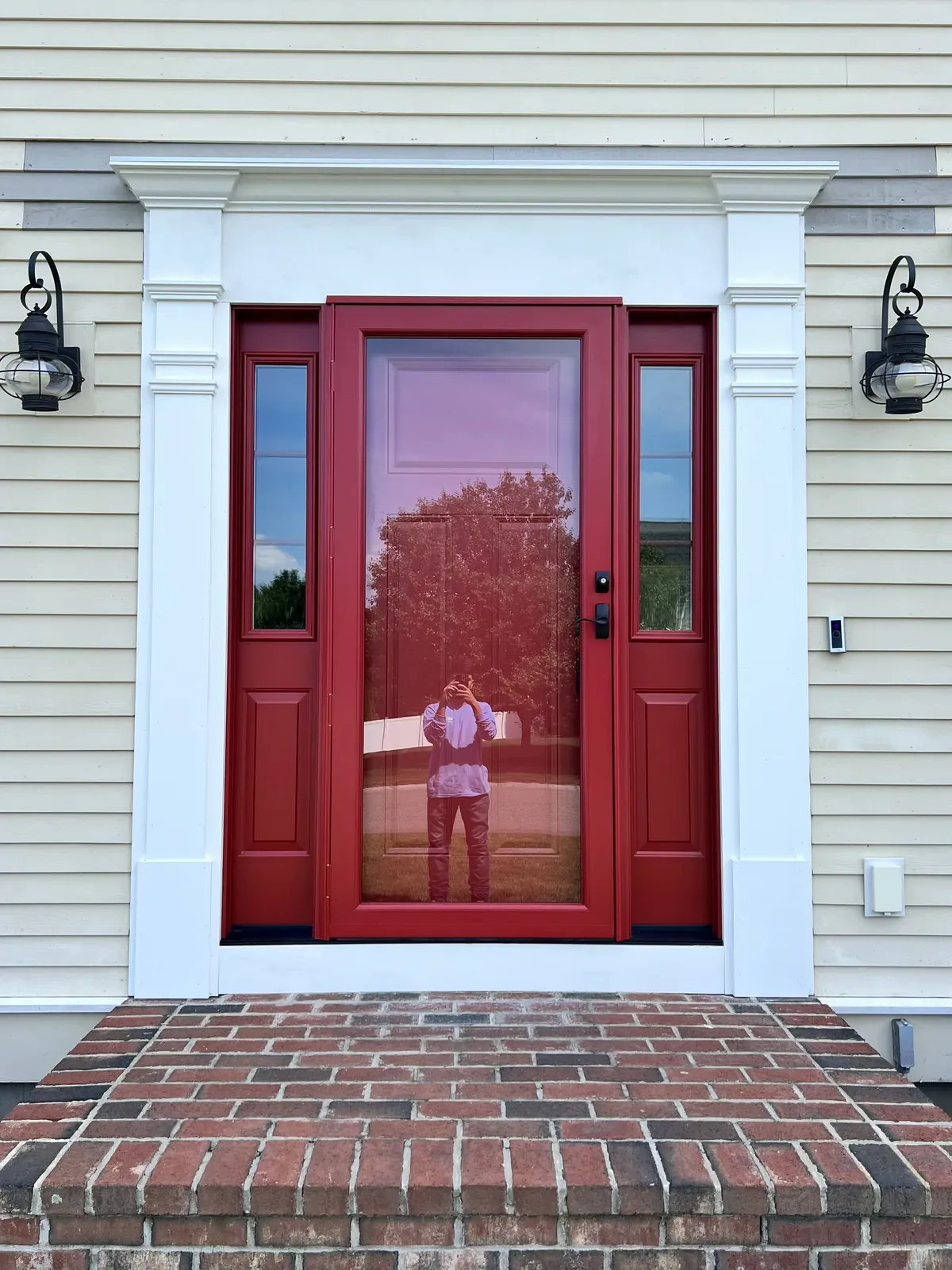 Deep red entry door with white surround on a brick step