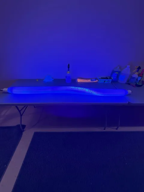 Glowing pipes transporting energy to a house, with machinery in the foreground and a cross-section of underground pipes.