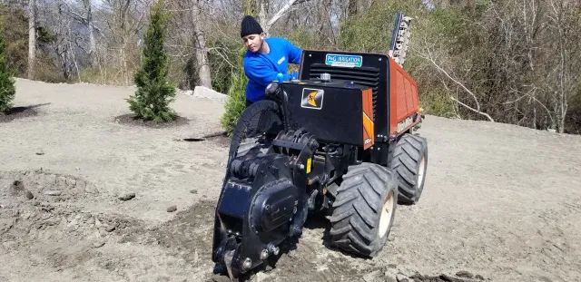 A man is driving a tractor on a dirt road.