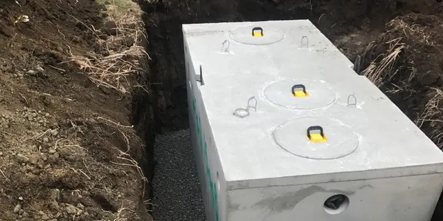 A white tank sitting in the middle of a hole.