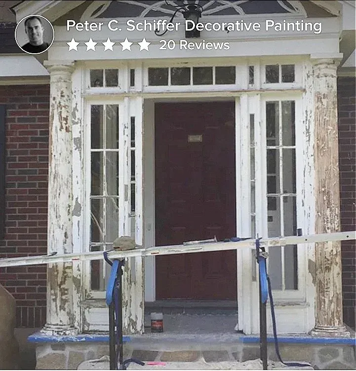 Exterior doorway with peeling white paint and a red door, preparation for repainting evident with equipment in front.