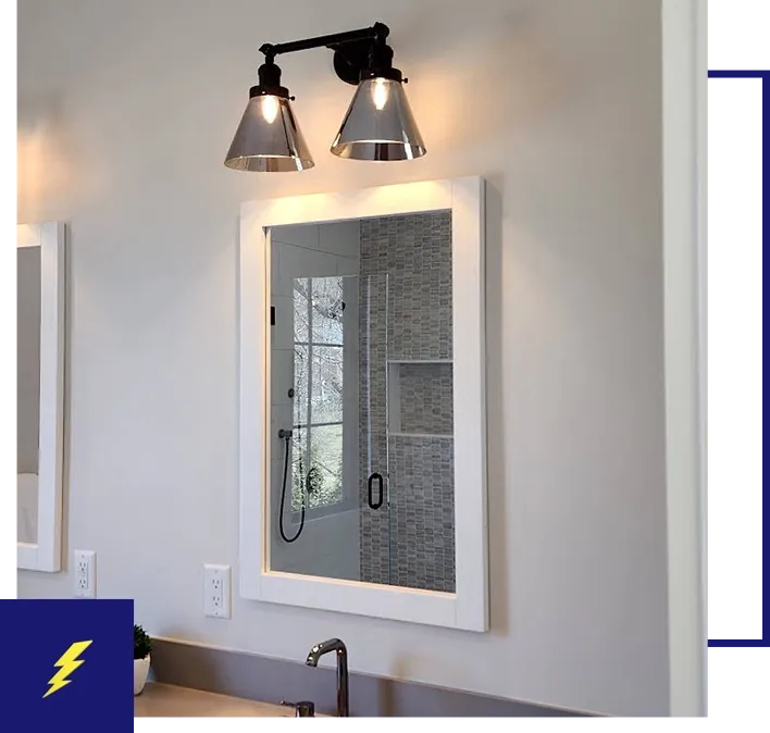 A bathroom with a mirror and lights on the wall.
