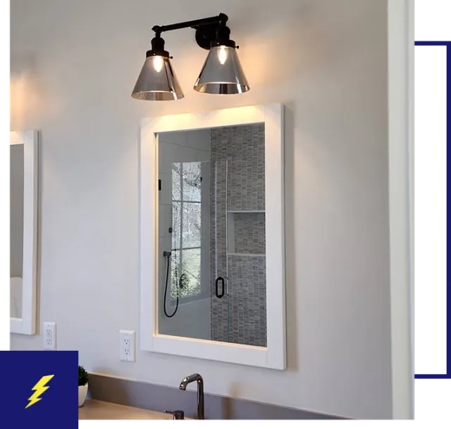 A bathroom with a mirror and lights on the wall.