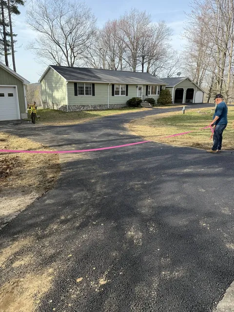 Freshly paved driveway with loamed and seeded edges
