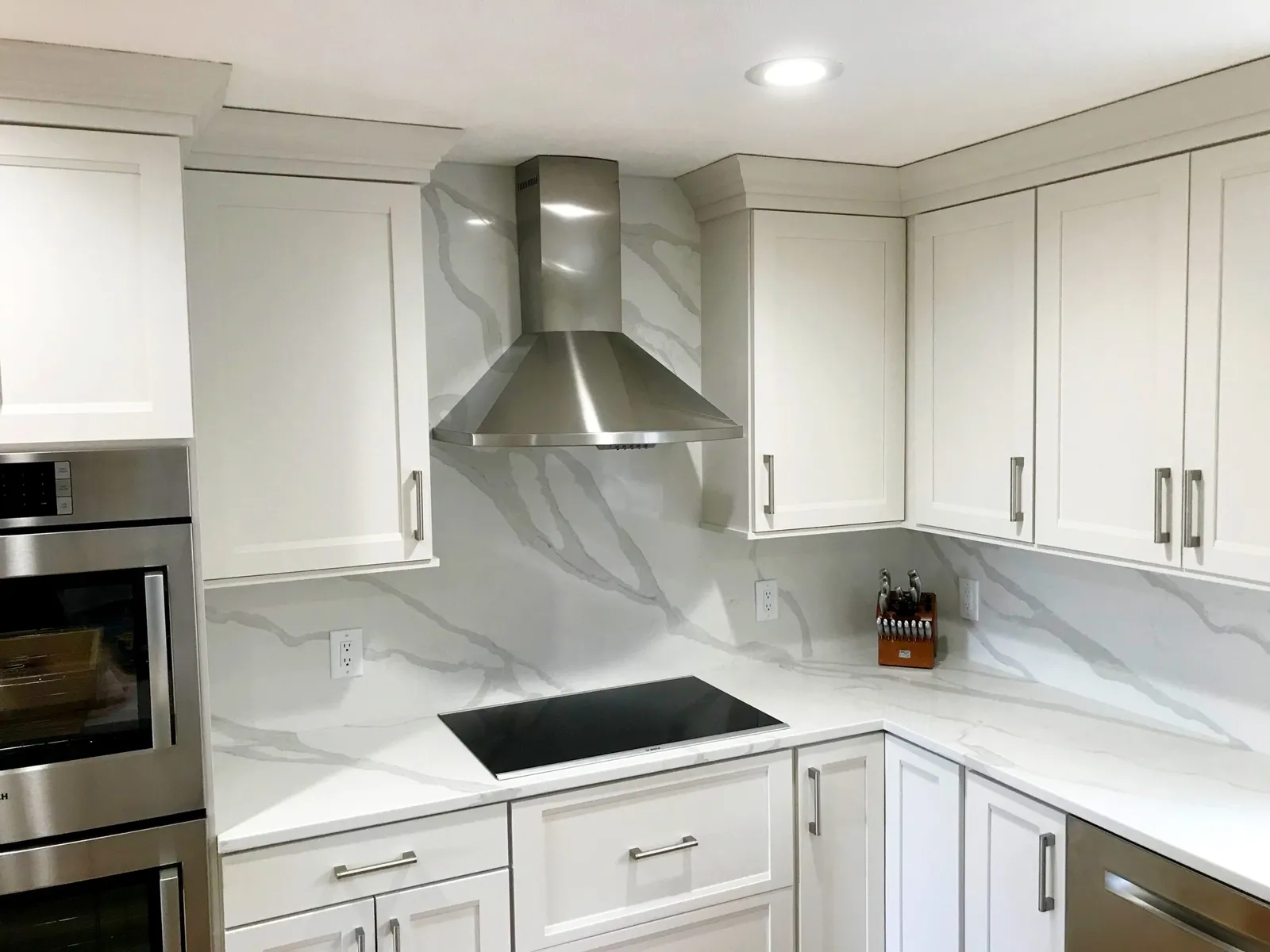 Custom kitchen renovation with white cabinetry and integrated appliances by KBK Woodworking