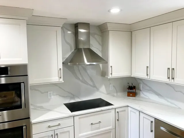 Custom kitchen renovation with white cabinetry and integrated appliances by KBK Woodworking