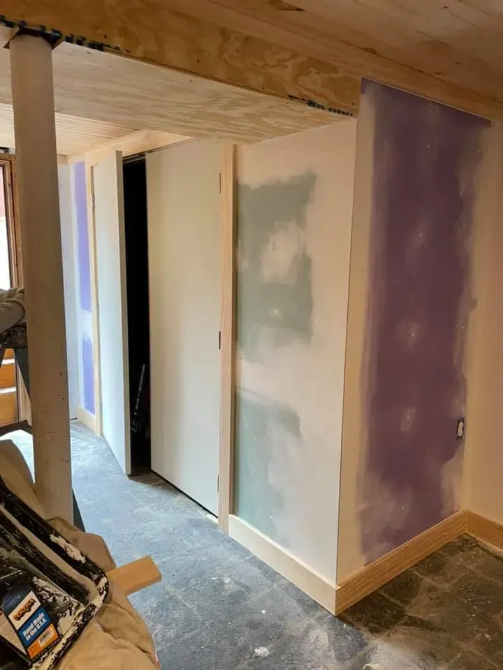 A room with purple walls and white walls is being remodeled.