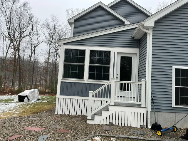 A house with a porch and stairs on the side of it.