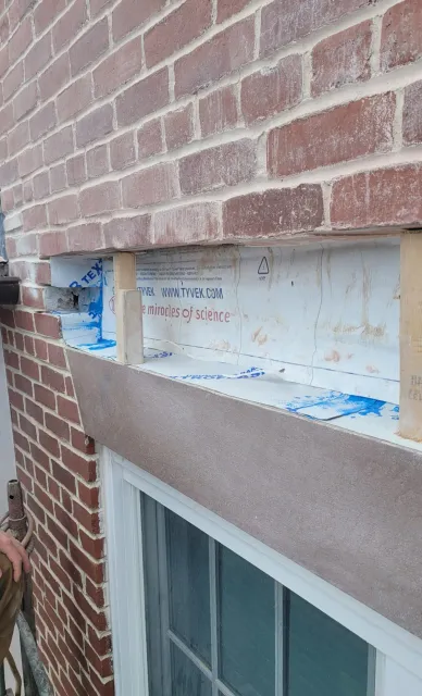A brick wall with some windows and a window sill