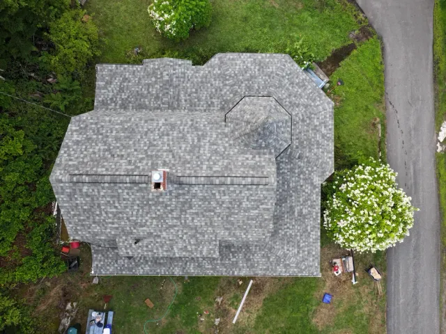 Aerial view of a complex grey shingle roof on a house