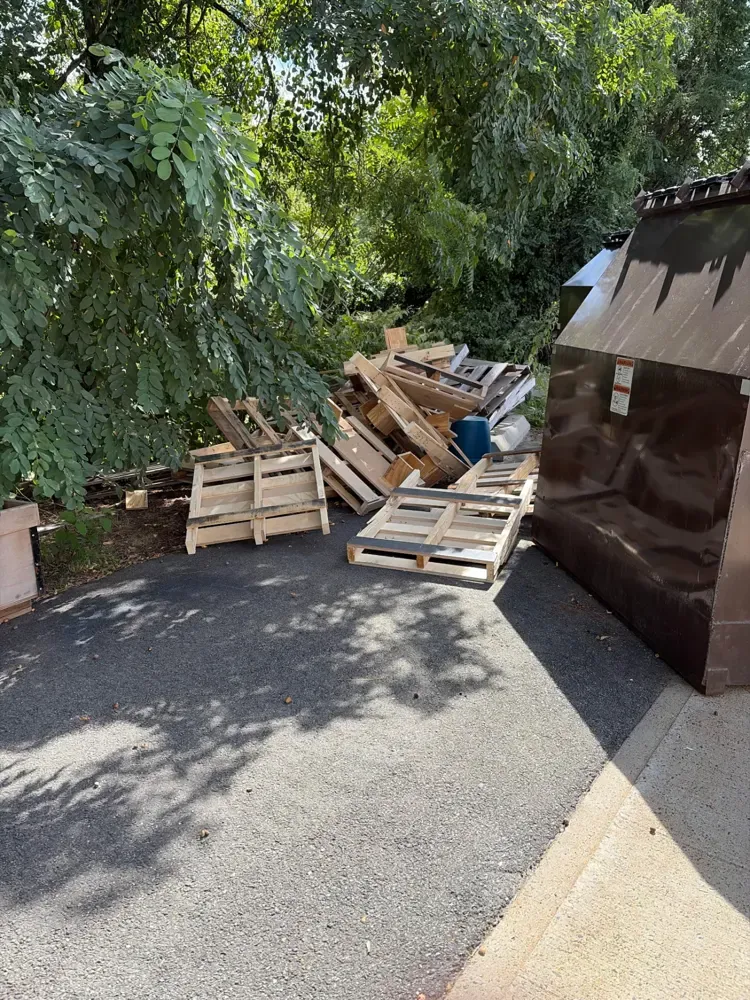 Wood pallets stacked outside a charter school before Pioneer Valley Junk Removal hauled them away