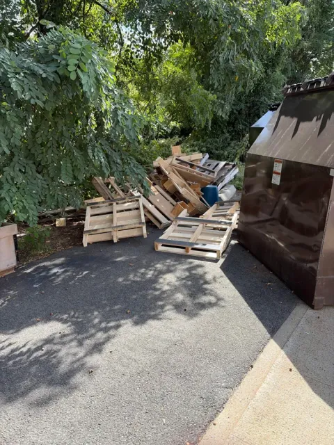 Wood pallets stacked outside a charter school before Pioneer Valley Junk Removal hauled them away