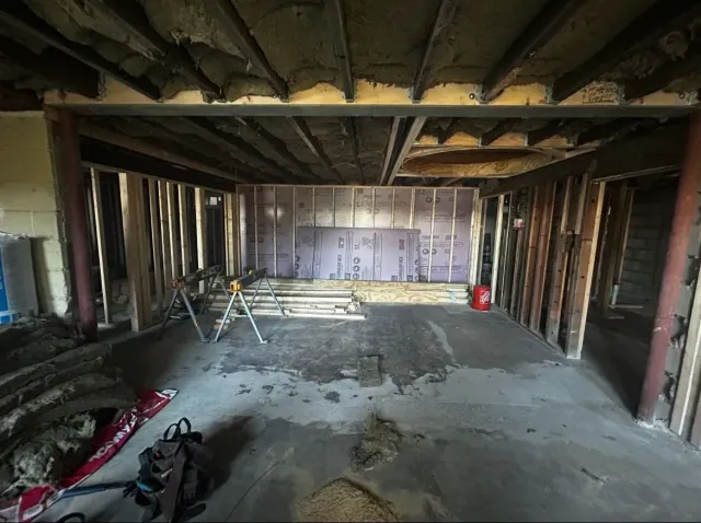 An empty room with a vacuum cleaner in the middle of it.