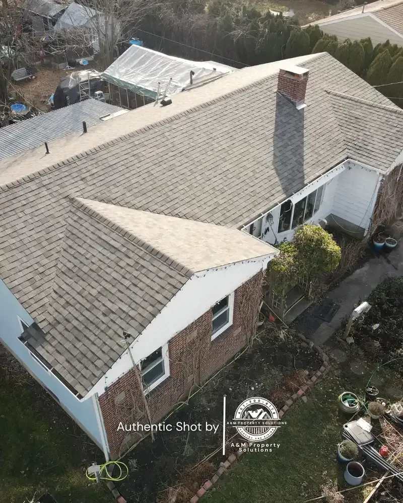 Newly installed architectural shingle roof on a Rhode Island home, photographed from above by A&M Property Solutions.