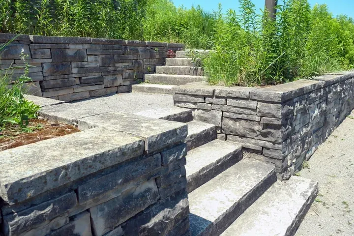 Stone steps and retaining walls with vegetation alongside.