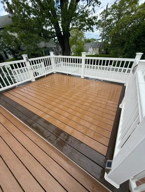 Two-tone composite deck with white railing freshly cleaned in Middlesex County, MA
