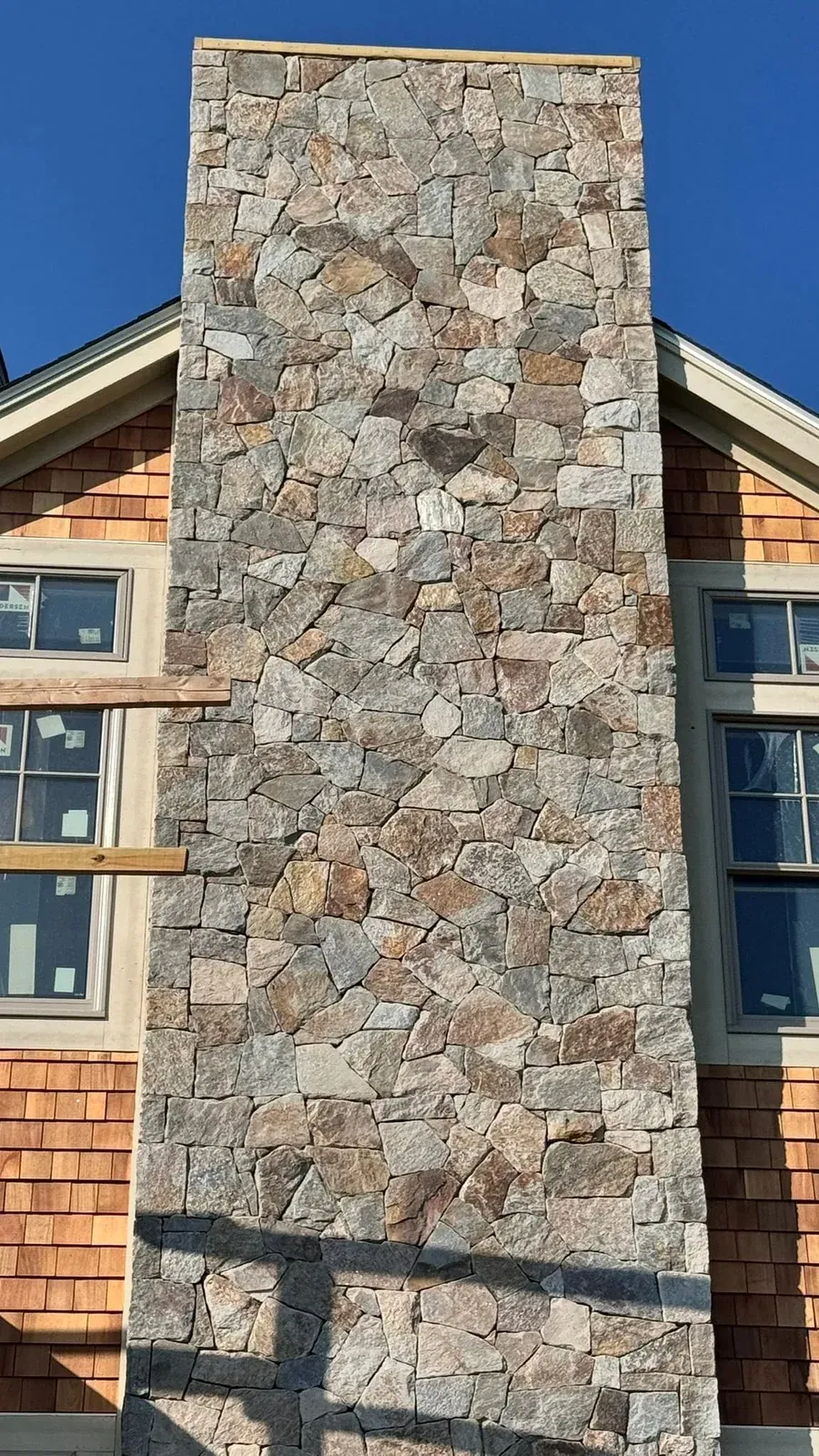 Natural stone veneer installed on a tall residential chimney
