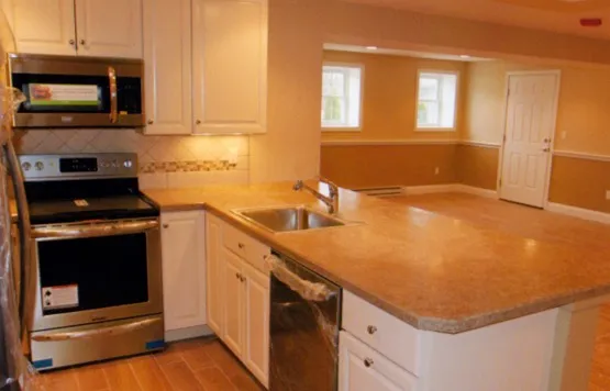 Finished lower-level kitchen with range and peninsula