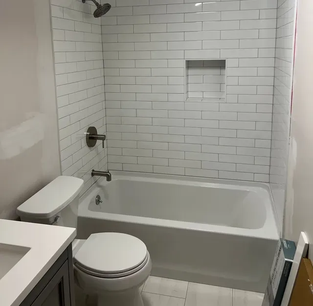 A bathroom with a toilet a tub and a shower