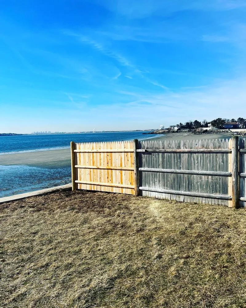 New cedar fence section joined to the existing weathered run at a shoreline property