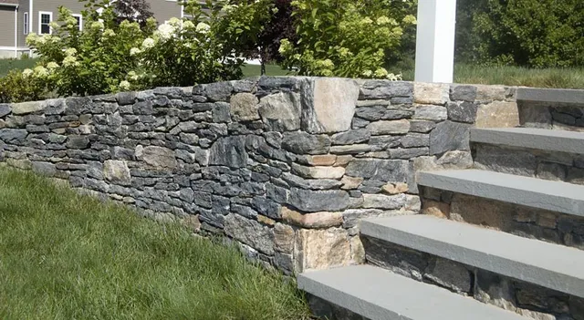 Natural stone retaining wall and landscape installation by The Hambelton Company