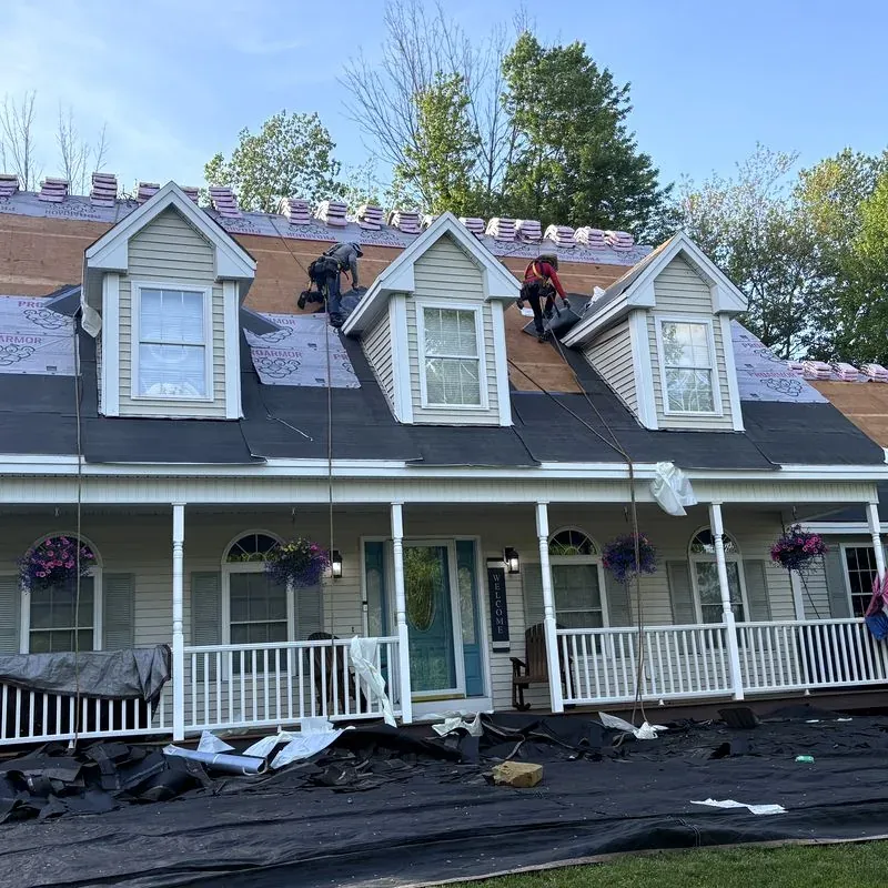 Roof replacement in progress on a dormered colonial