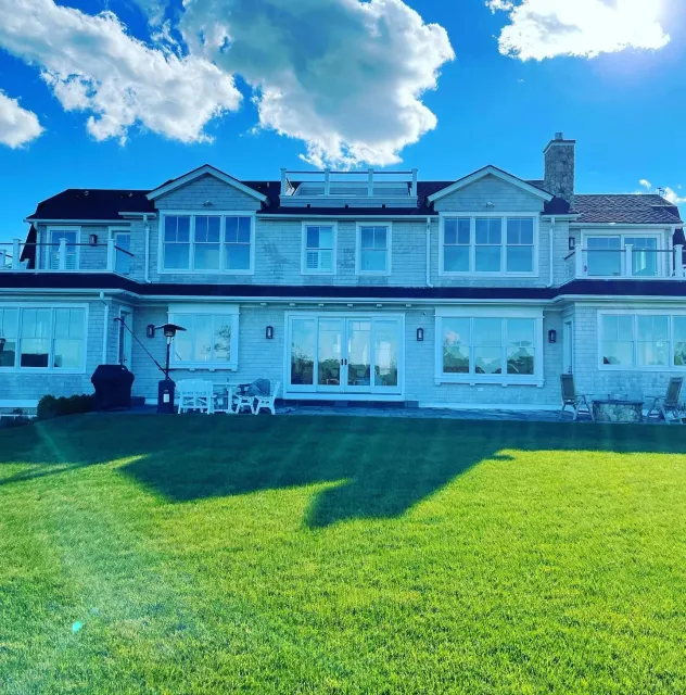 Clean window services for large waterfront home under blue sky | Window cleaning Cape Cod