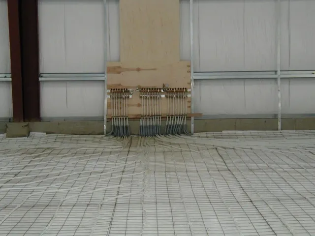 A concrete floor with a wooden wall in the background