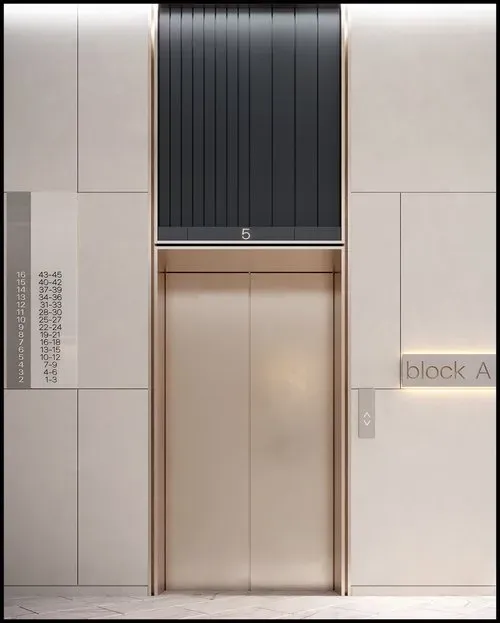 A photograph showcasing an elegant elevator design in a sophisticated lobby setting. The focal point is the custom elevator doors and frames, along with the extended transoms, all finished in a subtle, light bronze tone.