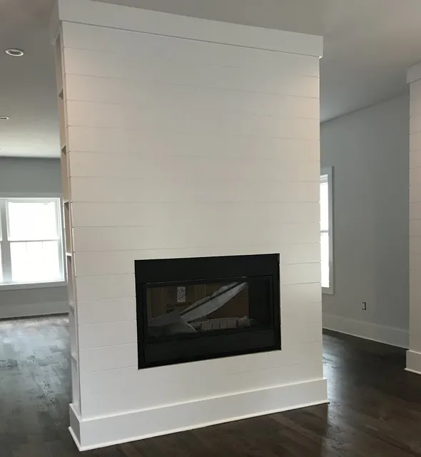 Custom white shiplap fireplace with dark hardwood floors