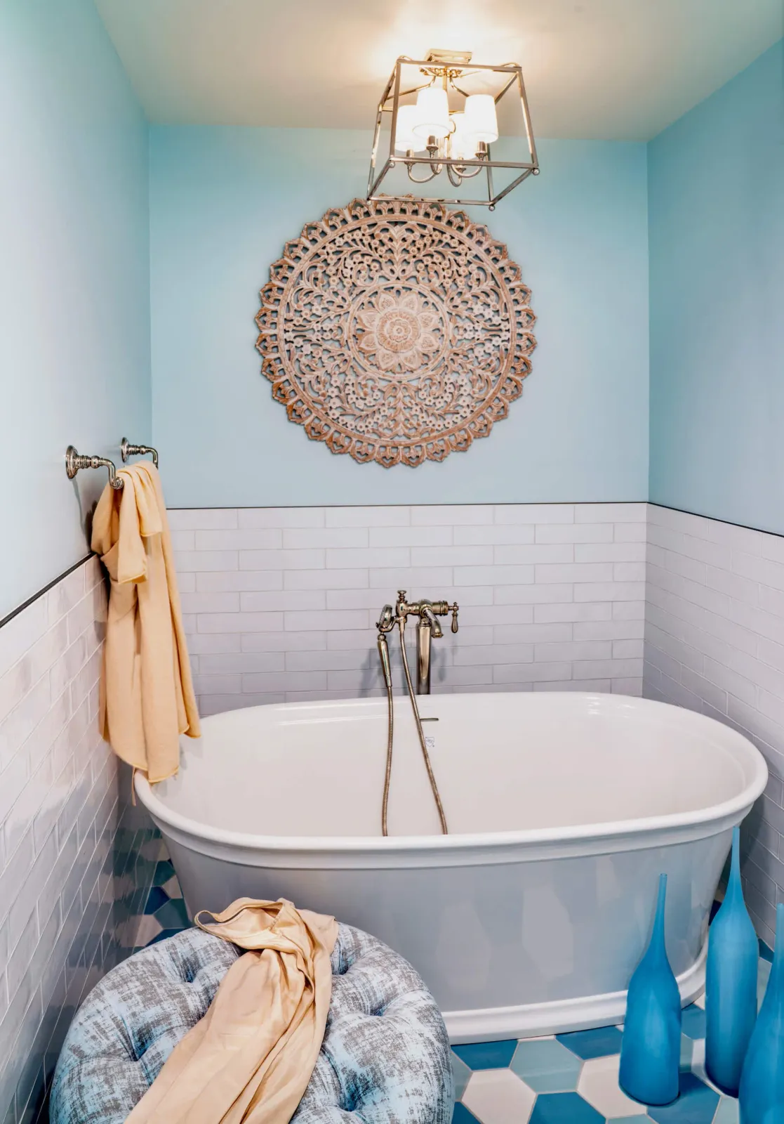 A bathtub with gold faucets and a towel hanging on the wall.