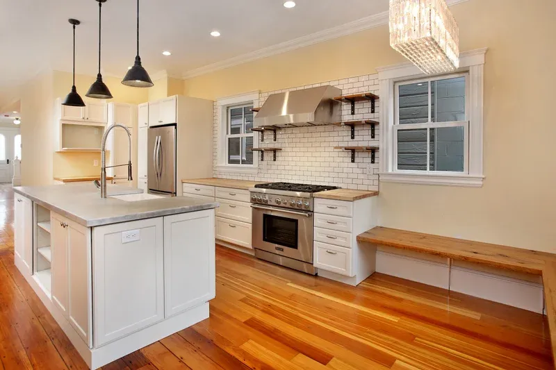 White kitchen with island, subway tile and built-in banquette