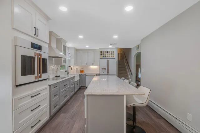A kitchen with white cabinets and a large island