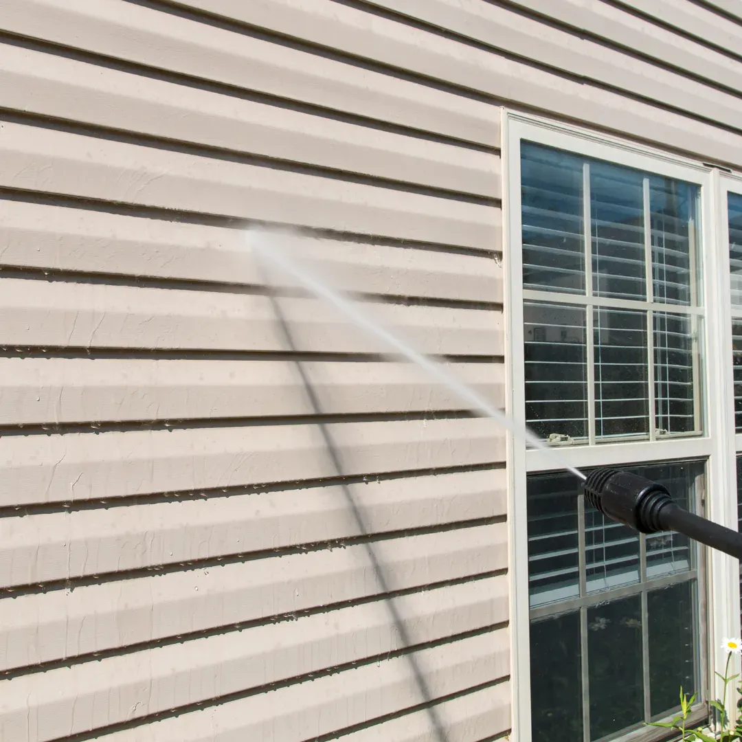 Pressure washing service cleaning exterior surfaces before a painting project.